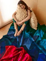 Almohadón cuadrado de lana color beige, con diseño geométrico en relieve. Relleno con funda de algodón, guata y restos textiles.