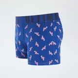 Pack de tres boxers para hombre. Incluye un boxer amarillo liso, un boxer azul marino con estampado de patos amarillos y un boxer azul con estampado de flamencos rosados. Todos tienen cintura elástica con la palabra "ULTIMATE" grabada.