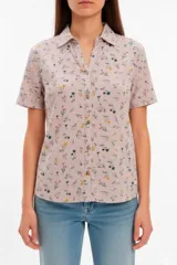 Camisa de manga corta y cuello camisero, confeccionada en tejido de jersey con estampado floreado multicolor sobre base rosada y cierre frontal de botones.