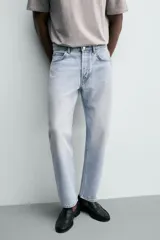 Jeans regular fit de denim de algodón en color gris con efecto lavado, tiro medio, diseño de cinco bolsillos y cierre frontal con botones.