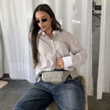 Lentes de sol con marco metálico dorado de forma ovalada y cristales oscuros. Diseño moderno y minimalista con protección UV400.
