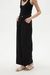Pantalon de jean estilo barrel, color natural, de tiro medio con bolsillos laterales y cierre frontal.