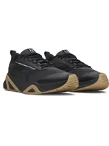 Championes de entrenamiento Under Armour modelo Charged Commit TR 5, color negro con detalles en beige en la suela. Presentan parte superior de malla transpirable con revestimientos de cuero, entresuela Charged Cushioning para absorción de impactos y suela de goma con refuerzos laterales.