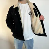 Chaqueta de pana color beige con forro de corderito en el cuello y el interior. Tiene cierre con botones, bolsillos en el pecho y bolsillos laterales.