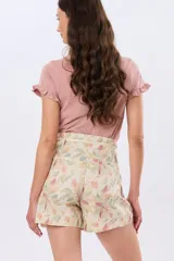 Short de lino con estampa botánica en tonos beige, verde y coral, de tiro alto con cordón ajustable en la cintura y bolsillos laterales.