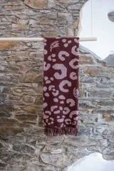 Manta jacquard con estampado animal print color borgoña y flecos en los bordes. Incluye logo de la marca Polonio en una esquina. Confeccionada en Italia.