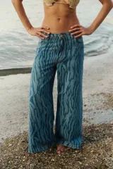 Pantalón de jean tiro medio, corte oversize y pierna ancha, con estampado láser acebrado tipo cebra.