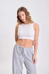 Musculosa corta blanca de tejido de punto acanalado, corte ajustado y cuello redondo.