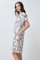 Vestido corto de lino color blanco con estampa abstracta en color chocolate, escote en V y mangas cortas.