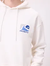 Canguro blanco con capucha y cordones ajustables. Presenta un estampado grande en la espalda con formas abstractas en tonos de azul y gris, y la palabra "RUSTY" en azul.