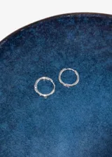 Par de aros tipo argolla de acero quirúrgico hipoalergénico color dorado.