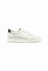 Championes de cuero en color blanco, con diseño minimalista, suela plana y detalle en contraste en el talón.
