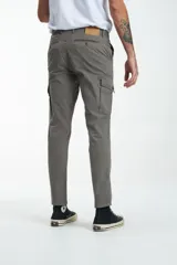 Pantalón cargo gris de gabardina, corte slim, con bolsillos laterales con solapa y bolsillos traseros con ojal y botón. Presenta efecto teñido en la tela.