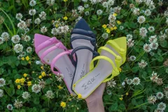 Sandalias negras de cuero con punta fina y tiras finas con nudos.