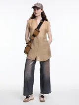 Camisa color beige sin mangas, con cuello mao y cierre frontal con botones.