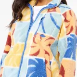 Campera de polar con cierre frontal, cuello alto y bolsillo en el pecho. Presenta un diseño estampado de bloques con motivos botánicos en tonos pasteles y vibrantes.