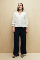 Pantalón negro de corte wide leg y tiro alto, con bolsillos laterales y traseros.