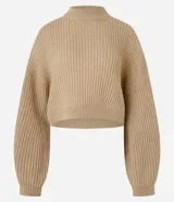 Suéter de punto negro texturizado con cuello redondo y mangas largas con puños ajustados.