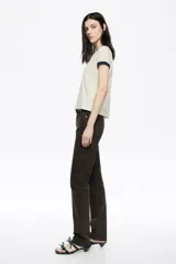 Pantalón de denim color marrón oscuro, tiro medio, corte ajustado y diseño de cinco bolsillos.