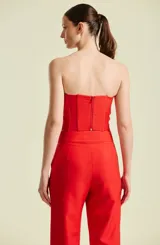 Top de mujer strapless color rojo, de corte estructurado estilo corsé con escote en corazón, confeccionado con costuras verticales que aportan definición a la silueta.