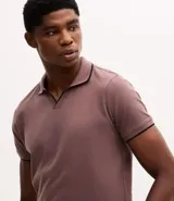 Camisa polo de manga corta confeccionada en algodón, con cuello en V y detalles en color contrastante en el cuello y los puños. Presenta un diseño de tejido en media malla, ofreciendo una textura suave y transpirable.