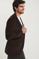 Saco sport de pana color marrón, con cuello de solapa, cierre frontal de dos botones, bolsillos laterales con tapa y puños con botones.