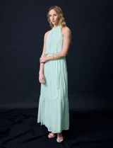Vestido largo de gasa color verde menta, marca Julia Jordan. Tiene escote halter, cintura elastizada con lazo de ajuste y abertura central en la espalda con botones.