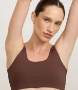 Top deportivo color marrón, sin copa, con escote redondo y breteles medianos.