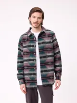 Camisa de manga larga con diseño de estampado étnico en tonos azules y beige. Presenta cuello clásico, cierre frontal con botones y bolsillos en el pecho.