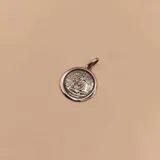 Medalla redonda de plata 925 con la imagen en relieve del Ángel de la Guarda protegiendo a un niño.