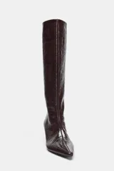 Bota de caña alta con acabado efecto craquelado en color marrón oscuro. Presenta un diseño de punta fina, tacón kitten y una estructura de calce fácil tipo pull-on.