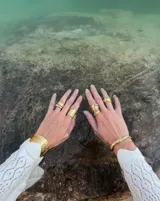 Brazalete rígido abierto de bronce con textura irregular.