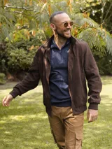 Campera de estilo casual confeccionada en tejido tipo gamuza color marrón, con cierre frontal completo, cuello alto y puños elásticos acanalados.