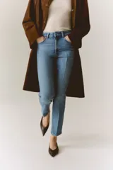 Jean tobillero de cinco bolsillos en denim de algodón con leve stretch, tiro alto y piernas rectas con pliegues frontales y posteriores.