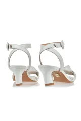 Sandalia de cuero blanca con tira delantera con nudo, tira al tobillo con hebilla y taco geométrico.