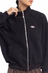 Campera negra de cuello alto con cierre frontal metálico completo, bolsillos laterales y logo bordado en el pecho.
