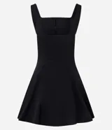 Vestido corto negro de corte evasé, con escote cuadrado y breteles anchos. Presenta costuras verticales en el frente y la espalda para definir la silueta.