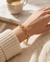 Pulsera dorada de acero con diseño de eslabones geométricos en forma de rombos.