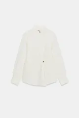 Camisa de cuello subido y manga larga con puños. Presenta un diseño de rayas verticales finas y cierre frontal con botones a la vista.