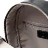 Mochila negra de símil cuero liso, con un compartimento principal con cierre, un bolsillo externo con cierre, un bolsillo interno con cierre y dos bolsillos internos abiertos. Tiene correa regulable y logotipo de XL Extra Large al frente en relieve.