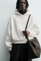 Sudadera tipo hoodie de corte boxy fit, confeccionada en tejido doble compacto de mezcla de algodón. Presenta cuello con capucha, manga larga y acabados en el mismo tejido.