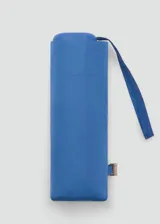 Paraguas mini plegable de color azul, con diseño liso y correa de mano a juego. Incluye detalle de placa metálica con logo de la marca.