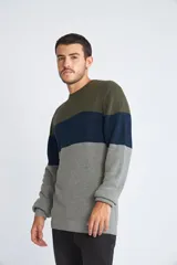 Sweater de tejido de punto con diseño color block en tonos verde, azul y gris. Presenta cuello redondo, mangas largas y corte regular.
