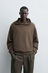 Sudadera tipo hoodie de corte regular, confeccionada en tejido de algodón ligero. Presenta cuello con capucha, manga larga y terminaciones en rib en puños y ruedo. Posee un acabado de aspecto lavado con tintado especial.