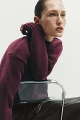 Jersey de punto liso con cuello subido, manga larga y acabados en rib en puños, cuello y ruedo.