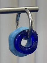 Aros tipo argolla de plata 925 con dijes circulares de vidrio en tonos azul y celeste.