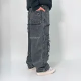 Pantalón jean de corte ultra baggy, color negro con efecto lavado. Presenta un diseño cargo con múltiples bolsillos laterales con bordes desflecados y detalles de costuras expuestas.