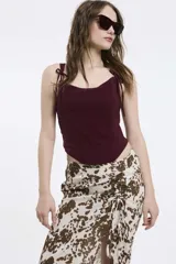 Top tipo corset color bordó, con escote recto, tirantes finos ajustables con lazo y bajo en punta.