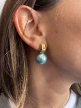 Aros colgantes compuestos por una esfera dorada lisa y una perla esférica en la parte inferior, con cierre de perno.
