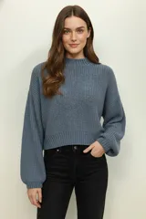 Sweater de tejido de punto grueso, color azul grisáceo, con cuello redondo y mangas largas abullonadas.